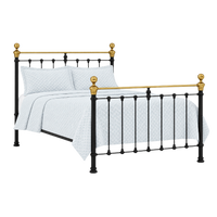 Orchids Lux Home Castile black and brass queen bed with sprung slats, white pillows, and a patterned comforter.