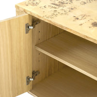 Close-up of a light natural wood cabinet with one door open, showing metal hinges and an adjustable shelf inside.