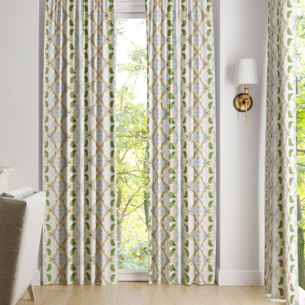 Laura Park Designs Dogwood Curtain Panels in white and green frame the window, highlighting the outdoor greenery.