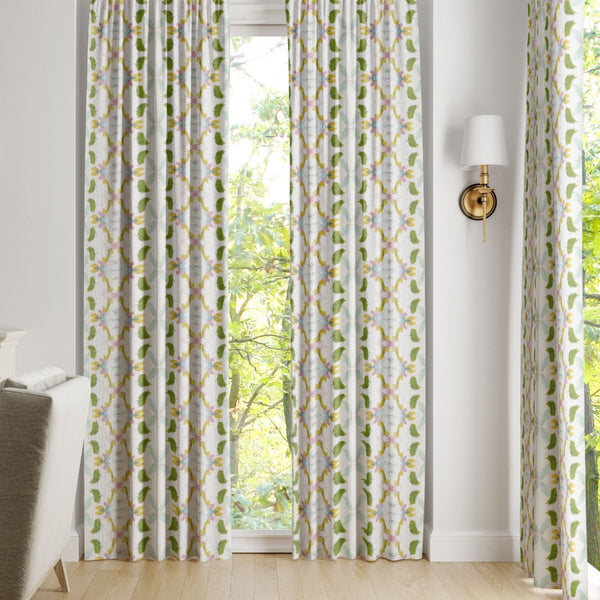 Laura Park Designs Dogwood Curtain Panels in white and green frame the window, highlighting the outdoor greenery.