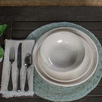 Place setting with white plates and Always Relish Double Line Cream Melamine Bowls (set of 4) on a blue placemat, accompanied by a fork, knife, and spoon next to a cloth napkin. The dishware is not only elegant but also dishwasher safe for easy cleanup.