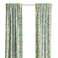 Light blue and green Elephant Falls Curtain Panels by Laura Park Designs hang before a window with trees outside.