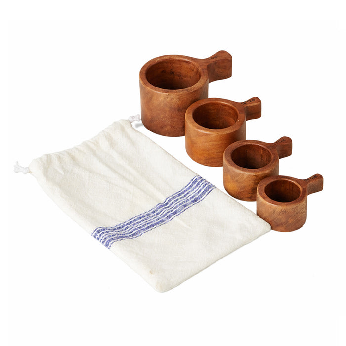 ETU Home French Bistro Wood Measuring Cups (set of 4) rest beside a white bag with a blue stripe.