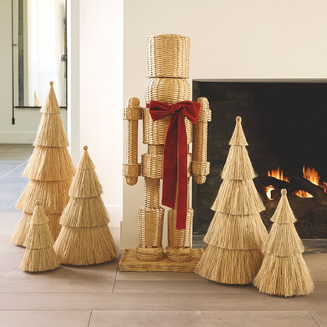 The All Weather Rattan Nutcracker with Red Bow by Santa Barbara Design Studio adds festive charm by the fireplace.