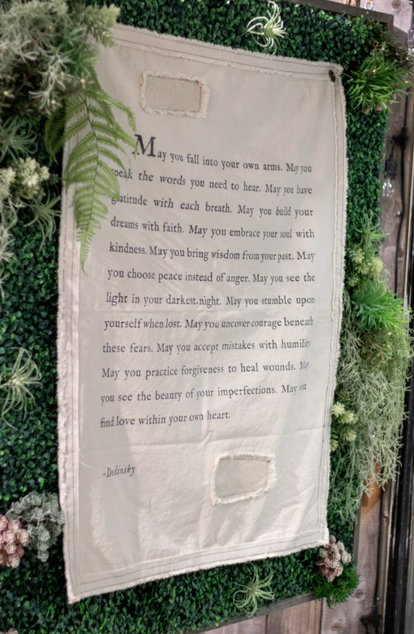 Textile with a prayer or blessing on a green leafy background