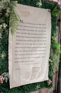 Textile with a prayer or blessing on a green leafy background
