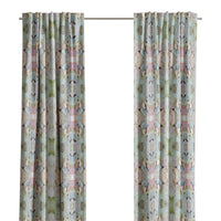 Martini Olives Curtain Panels by Laura Park Designs hang by a window, letting in natural light near an armchair.