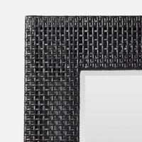Close-up of a black woven frame on a white background