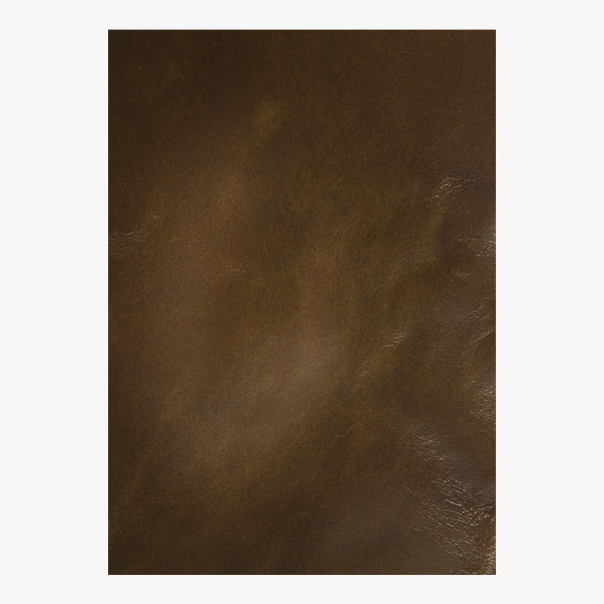 The Leather Wrapped Antique Bronze Mirror by Mirror Home features smooth brown leather with subtle highlights and natural variations.