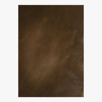 The Leather Wrapped Antique Bronze Mirror by Mirror Home features smooth brown leather with subtle highlights and natural variations.