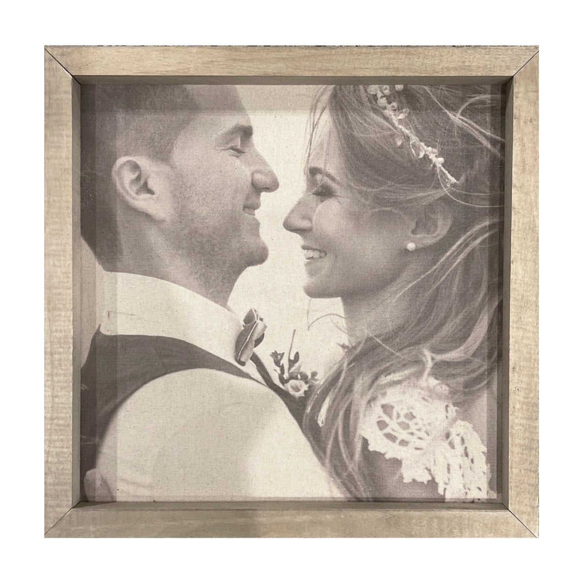 A custom photo panel from Brayden & Brooks, featuring a framed black-and-white photograph of a couple on their wedding day, captures the bride in a lace dress with a floral headpiece and the groom in a suit with a bow tie. The Thin Wooden Frame, available in various sizes and finishes, perfectly complements any photo gallery wall.