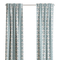 Laura Park Designs' Palm Mist Curtain Panels in light blue with a white geometric pattern hang by a window.
