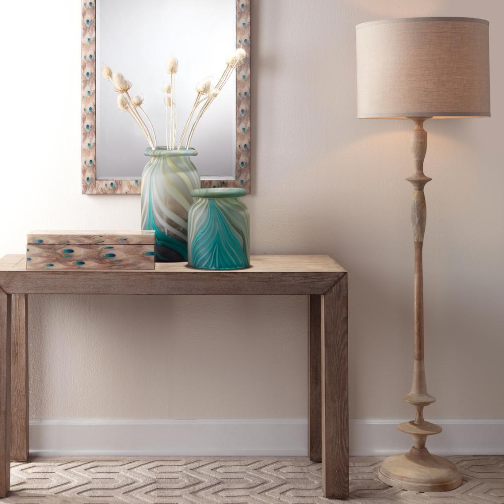 Decorative setup with a wooden table, vases, and a floor lamp against a neutral wall.