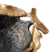 Close-up of a textured sculptural bow; with a dark charcoal-black interior and a metallic gold-toned outer edge, shown against a plain white background.