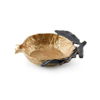 A small decorative bowl with a textured gold interior and a dark, leaf-like exterior, photographed on a clean white background.