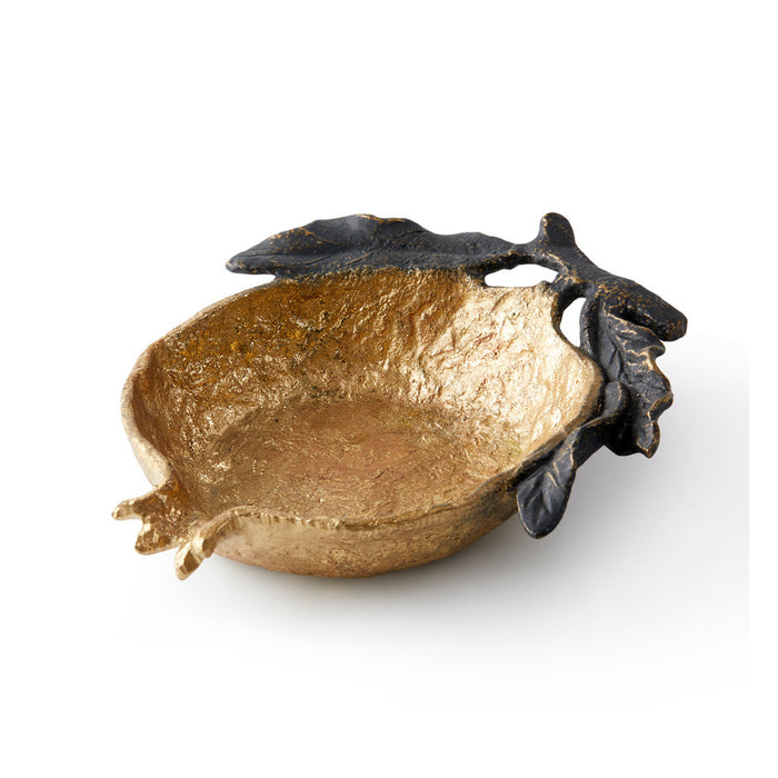 A decorative pomegranate-shaped bowl with a textured metallic gold finish and dark, leafy side accents, photographed on a clean white background.