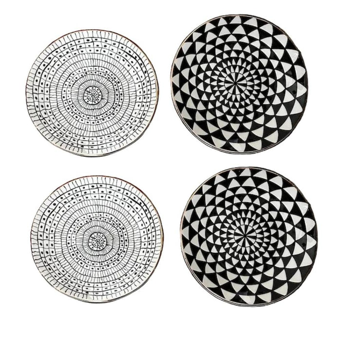Four black and white patterned coasters on a white background