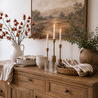 Rustic sideboard styled with striped napkins, candles, dishes, and Napa Home & Garden Pomegranate 36″ Branches.