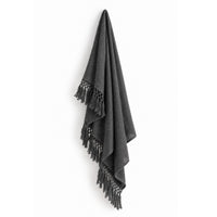 The Auskin Alpaca Charcoal Gray Cool Throw with tasseled edges hangs against a white background.