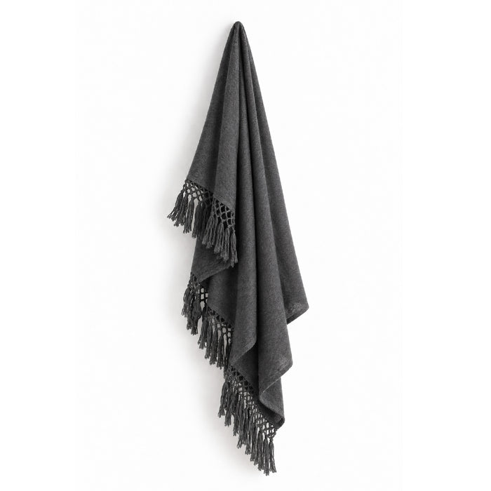 The Auskin Alpaca Charcoal Gray Cool Throw with tasseled edges hangs against a white background.