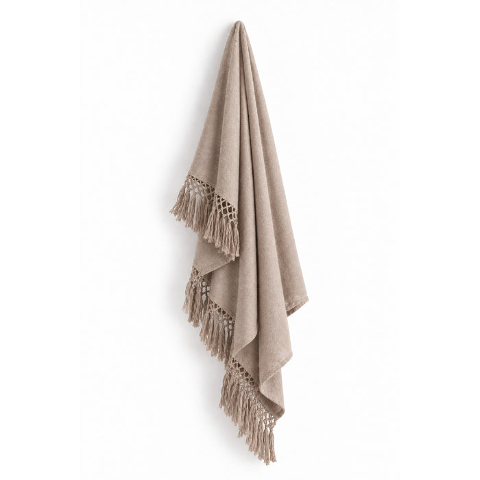 Auskin’s Alpaca Beige Cool Throw with fringes, made from luxury fiber, displayed against a white wall.
