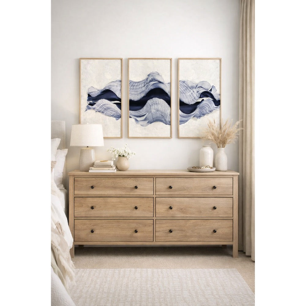 Wooden dresser with abstract wall art in a bedroom setting