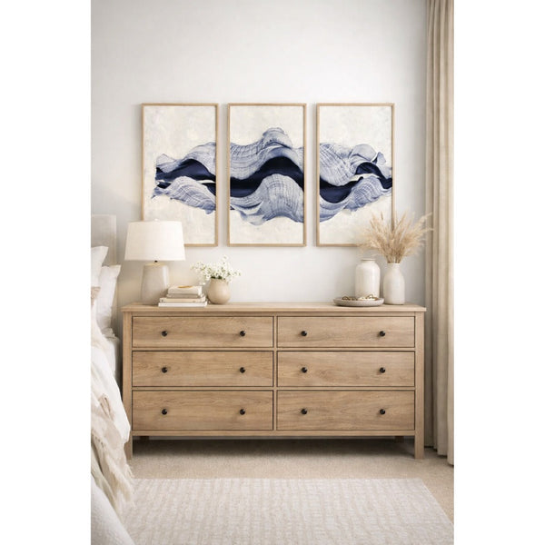 Wooden dresser with abstract wall art in a bedroom setting