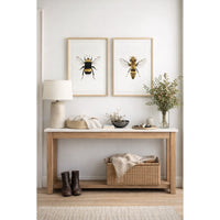 Nest living room with a wooden bench, lamp, and framed bee art on the wall.