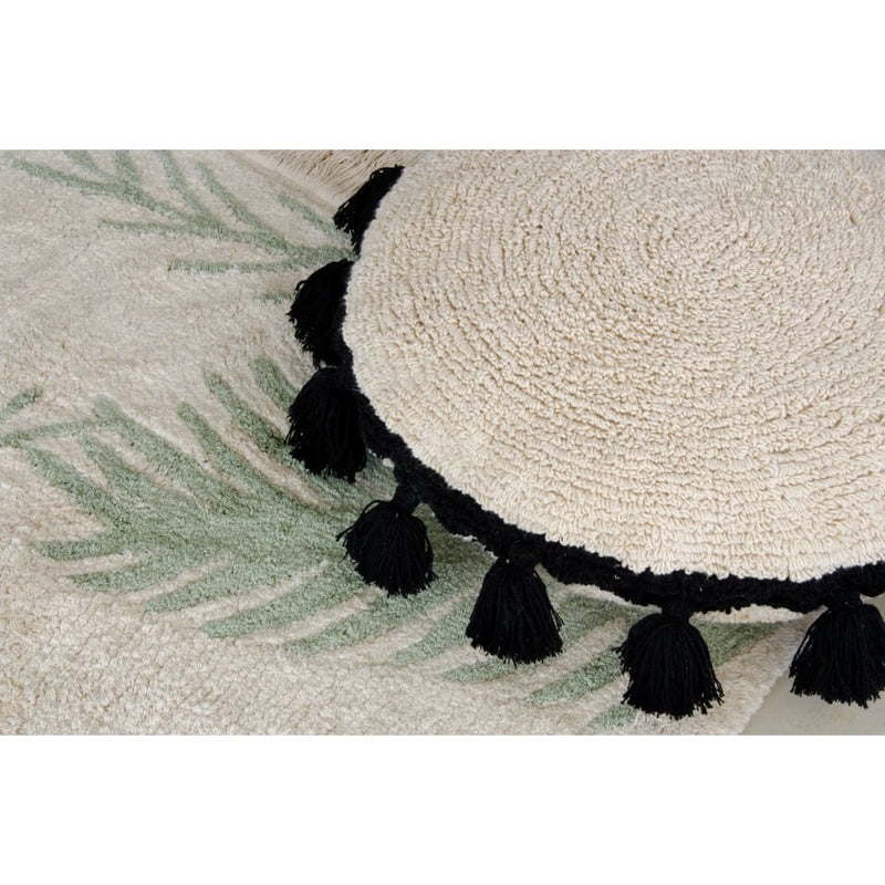 Circle Black Tassel Cushion by Lorena Canals, textured beige with black pom-poms, viewed from above, washable.