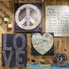 The L-O-V-E Gallery Wrapped Canvas Wall Art Print by Sugarboo & Co. showcases a peace sign, heart, and "LOVE" text on a wood background, offering a retro vibe. It's perfect for enhancing your bedroom with its gentle love quotes, complemented by surrounding plants and decor.