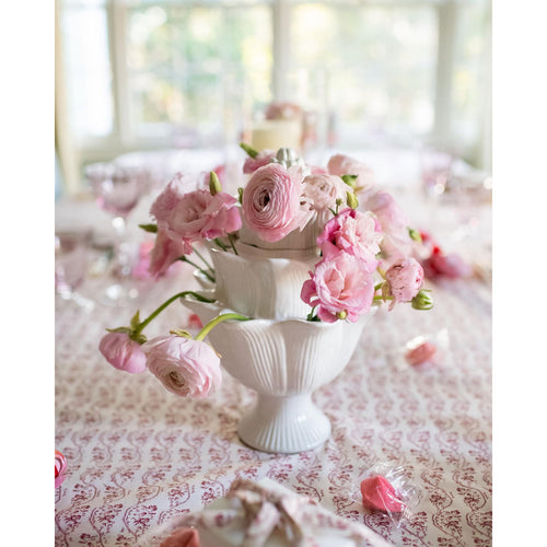 An ivory Small Artichoke Tulipiere by Abigails, elegantly displayed on a patterned tablecloth, brightens up the dining room display.