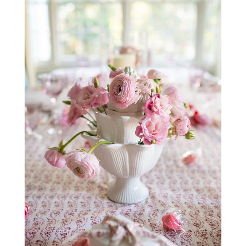 An ivory Small Artichoke Tulipiere by Abigails, elegantly displayed on a patterned tablecloth, brightens up the dining room display.