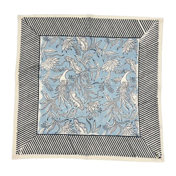 Set of 4 square napkins named Flowers + Feathers Cabana from Abigails, featuring a blue and white birds and flowers pattern, bordered by black and white diagonal stripes.