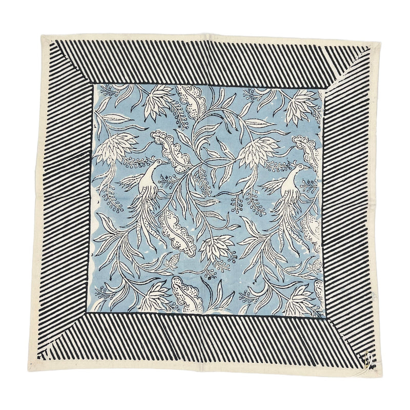 Set of 4 square napkins named Flowers + Feathers Cabana from Abigails, featuring a blue and white birds and flowers pattern, bordered by black and white diagonal stripes.