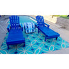 Two blue lounge chairs by a pool, one with a tie-dye towel, on Pattern 70 Echoes From The Bells Vinyl Floorcloth.