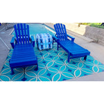 Two blue lounge chairs by a pool, one with a tie-dye towel, on Pattern 70 Echoes From The Bells Vinyl Floorcloth.