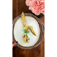 Rustic Grey Twig Charger by Kalalou elegantly placed on a round wicker tray, creating a charming tablescape with pink flowers nearby.