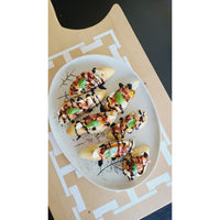 Crostini topped with tomatoes, mozzarella, fresh basil, and balsamic glaze are elegantly presented on the COCOCOZY Square Link Large Serving Board by BSEID. The rustic touch of reclaimed wood adds a decorative layer to this delightful appetizer display.