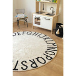 neutral black round rug ABC playroom