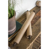 Two Hanging Note Rolls (22") with Antique Brass Clips by Kalalou sit on a rustic wooden table next to a potted plant and books.
