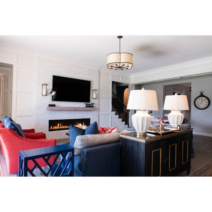 Modern living room with a TV, fireplace, colorful sofas, and Kalalou candle wall sconces by the staircase.