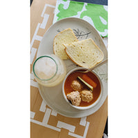 A bowl of soup with meatballs and vegetables, accompanied by two slices of bread and a glass of iced drink, elegantly presented on the BSEID COCOCOZY Square Link Large Serving Board, crafted from reclaimed wood.