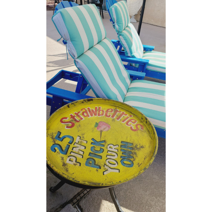 The Retro Strawberries Metal Tray by BSEID features a charming "Pick Your Own Strawberries 25¢ pint" design, perfectly complementing the vintage feel of striped blue and white lawn chairs.