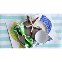 A set of Sindoor Green Screened Napkins by Allem Studio, accompanied by a starfish, plate, and small white bowl, rests on a background with striped and wave-patterned designs featuring hand screen-printed artwork.
