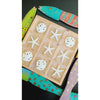 The Painted Recycled Wood Wall Art (set of 4) by Kalalou features a tic-tac-toe board with starfish and sand dollars as pieces, surrounded by colorful wooden fish on a black background, all hand-painted in vibrant tropical colors.