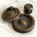 Phillips Scott's Bentley Drawer Buffet features three brass pulls—two circular rings and one round knob—on white marble.