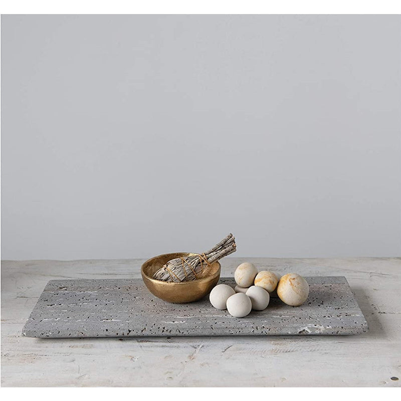 The Travertine Marble Serving Tray by BSEID, featuring a wooden bowl, a bundle of herbs, and round white stones, creates an organic aesthetic on the minimalist surface. The natural vibe is further enhanced by the travertine marble finish, seamlessly blending into any serene space.